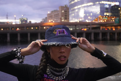 Person wearing a blue bucket hat with a cityscape in the background